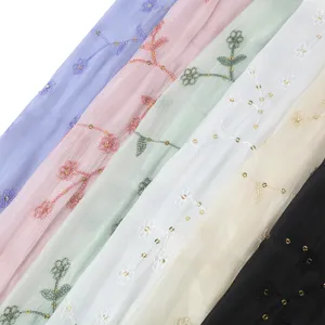 Vista dettagliata di sciarpe in chiffon ricamate con paillettes colorate e motivi floreali.