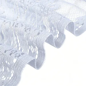 Close-up detail of light blue lace fabric, delicate hollow floral weave pattern and texture.