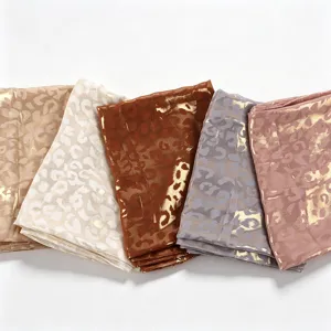 Detail shot of five metallic foil leopard print chiffon scarves in assorted elegant colors.
