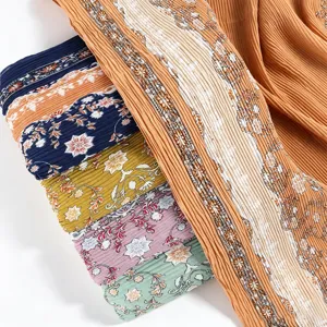 Exquisite pleated printed silk hijab detail showing vibrant floral patterns and soft fabric texture.