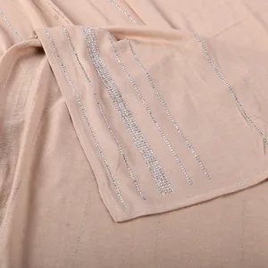 Gedetailleerd aanzicht van de elegante beige modalsjaal met strass, zachte textuur en strepen.