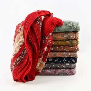 Details of pleated printed hijab scarf showing fabric texture and vibrant floral patterns.