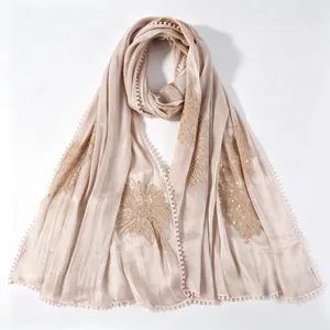 Close-up detail of vintage embroidered long scarf with sequins and delicate lace pompom edge trim.