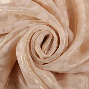 Detailed close-up view of smooth shimmering chiffon fabric with metallic gold print texture.