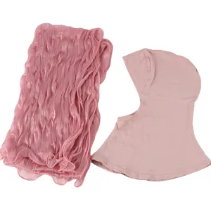 Écharpe longue rose à paillettes métalliques et bonnet intérieur assorti en détail.