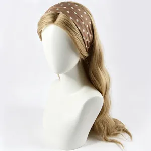 Vue de détail d'un bandeau large marron à pois blancs sur une belle tête de mannequin.