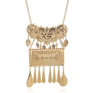 Collana statement dorata con intricate incisioni in metallo e delicati ciondoli a foglia e a goccia.