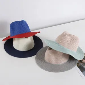 Vista detallada de sombreros de paja bicolor tejidos con ala y copa en contraste.