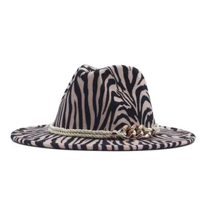 Primo piano del cappello fedora con stampa zebrata e dettaglio di catena metallica.