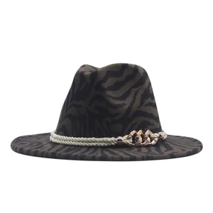 Dettaglio del cappello fedora in feltro con motivo zebrato e catena dorata decorativa elegante.