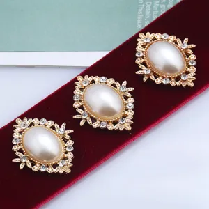 Vintage oval faux pearl rhinestone alloy buttons set on rich red velvet ribbon background.