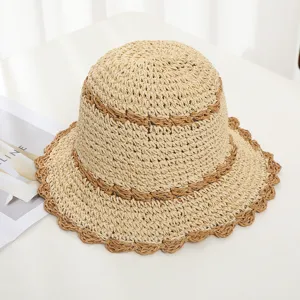 Primer plano del sombrero de pescador de paja tejida con ala ondulada y rayas de color.