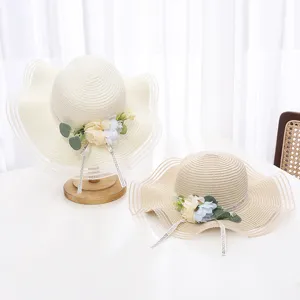Chapeau de paille floral avec bord en filet ondulé et ruban pour vacances à la plage, détail.