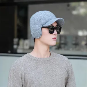 Men's winter knitted hat detail view, thick warm fleece lined cap with earflaps and brim.