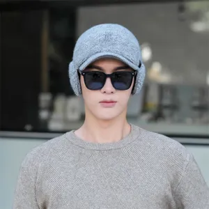 Close-up view of the warm winter knit hat with earflaps and visor, showing cozy knit texture.