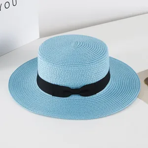 Blue flat top straw hat with black bow ribbon detail, perfect summer beach sun protection.