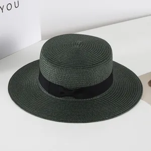 Detailed view of the dark green flat top straw hat with elegant black bow ribbon.