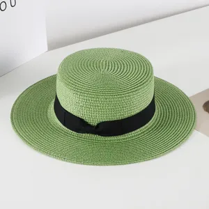 Green straw boater hat detail view, featuring a classic black ribbon bow on white background scene.