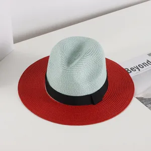 Detailed view of women summer straw hat with mint crown, red wide brim and black bow ribbon.