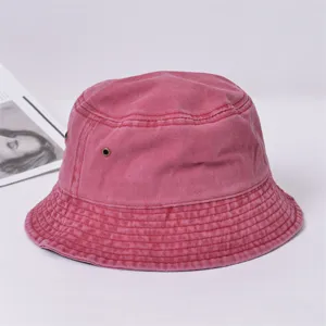 Gros plan détaillé dubob en denim lavé rose montrant le tissu texturé et l'œillet.