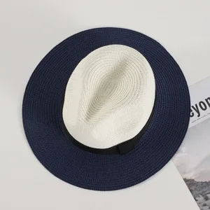 Details of the stylish summer straw hat featuring a chic two-tone wide brim and black bow ribbon.