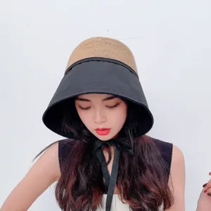 Close-up detail of the contrast color sun bucket hat with straw and black fabric.