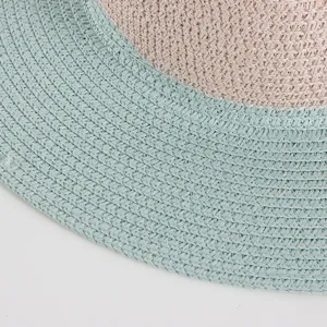 Detalle del sombrero de paja bicolor con textura fina, ideal para la protección solar veraniega.