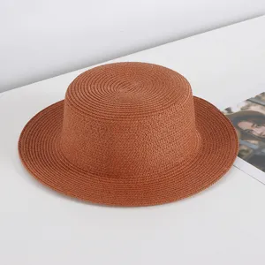 Elegant brown straw boater hat for women, ideal for summer beach sun protection.