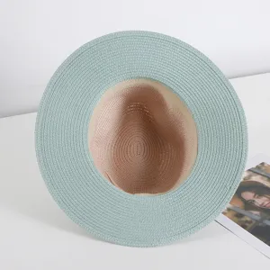 Vista detallada del sombrero de paja bicolor tejido que muestra textura y elegante ala.