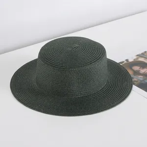 Detail view of the dark green flat top straw hat, showcasing woven texture and wide brim design.