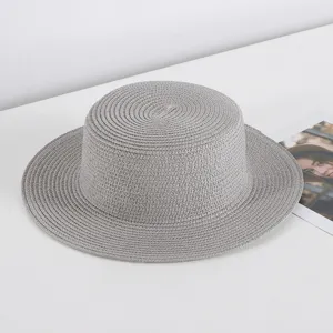 Grey flat-top straw hat detail view, featuring woven texture and wide brim for summer sun protection.