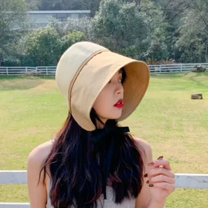 Outdoor sun protection detail shot of stylish color-blocked sun hat with wide brim and tie.