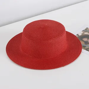 Red straw hat detail shot, flat top design, perfect for summer beach sun protection and travel.