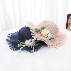 Détails rapprochés de beaux chapeaux de paille d'été avec fleurs et rubans en résille.