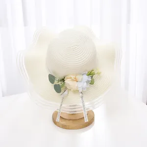 Gros plan sur le détail d'un chapeau de paille d'été élégant, avec fleurs en tissu et feuilles.