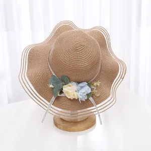 Vue detaillee d'un chapeau de paille d'ete pour femme a bord ondule et beau decor floral.