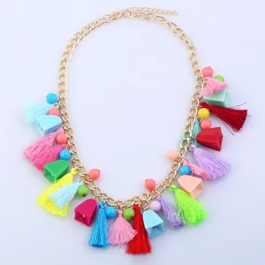 Bohemian multi-color tassel necklace detail featuring vibrant charms and a gold chain.