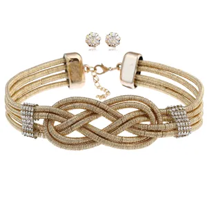 Nahaufnahme von mehrstrangigen geflochtenen goldenen Choker Halskette Ohrringen Strass.