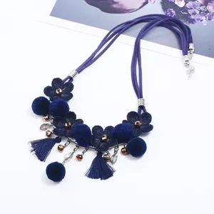 Navy blue suede cord necklace with fabric flowers, pom poms, and tassels for women.