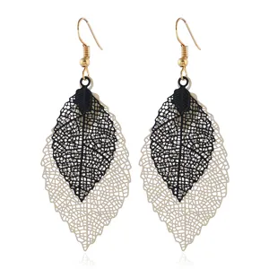 Nahaufnahme Detail der doppelten hohlen Blattohrringe mit elegantem Schwarz-Gold-Design.
