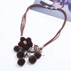 Bohemian braided flower necklace with cute pom-pom tassels and metal charms for women.