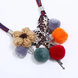 Boho pom-pom flower tassel necklace detail, multi-strand suede cord statement jewelry for women.
