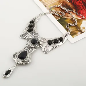 Vintage boheemse statement ketting met versierde zilveren legering en zwarte stenen.