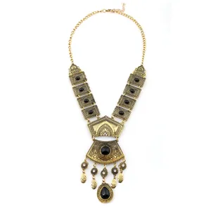 Collana statement dorata vintage con pietre nere, design in filigrana e pendenti pendenti.