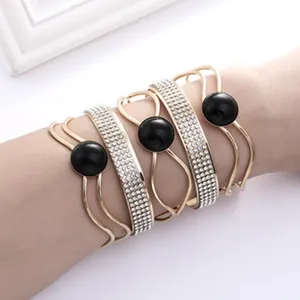 Set di bracciali rigidi dorati multistrato con strass e perle nere da donna alla moda.