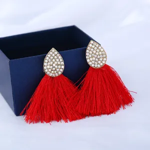 Nahaufnahme von Strass-Tropfen-Ohrringen mit roten Quasten und feiner Handwerkskunst.