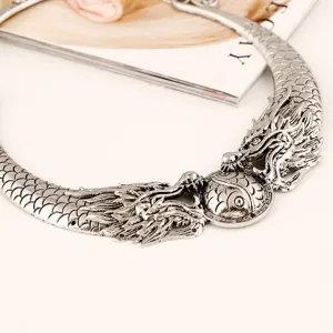 Collar gargantilla vintage de dragón plateado, detalle de joyería gótica étnica texturizada.