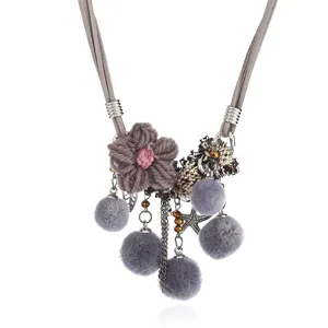 Bohemian grey suede cord statement necklace with knitted flower and plush pom-pom pendants.