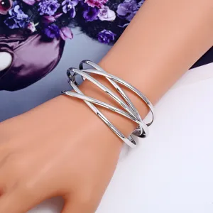 Detailansicht eines mehrschichtigen silbernen offenen Metallarmbands im Vintage-Stil.