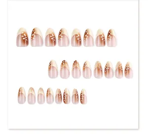 Almond press on nails detail view, french gradient brown design with white dot patterns.